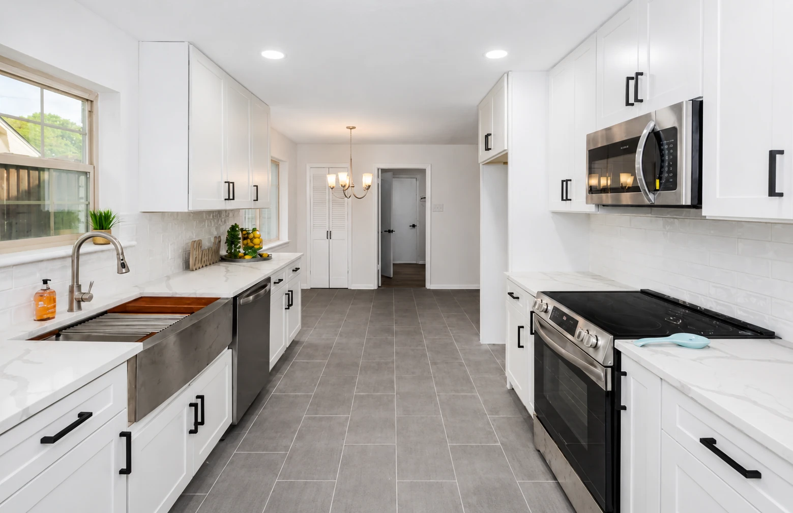 Open-concept kitchen remodel in Dallas, TX with farmhouse sink and gray plank flooring