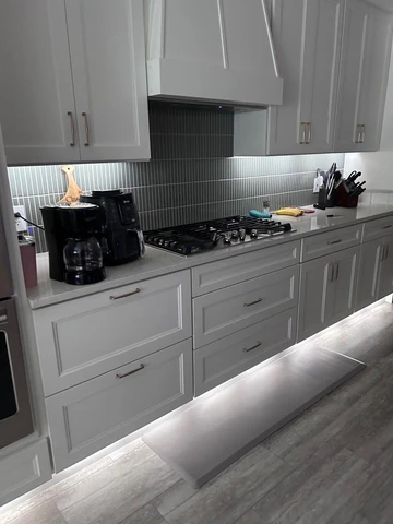 Richardson, TX kitchen with under-cabinet lighting and stone backsplash