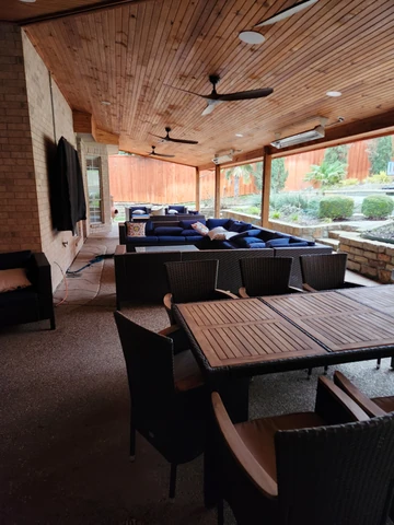 Outdoor living space in Garland, TX with a stained cedar ceiling and ceiling fan