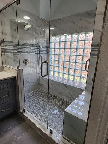 Walk-in shower remodel in Rowlett, TX with a glass enclosure and pebble floor